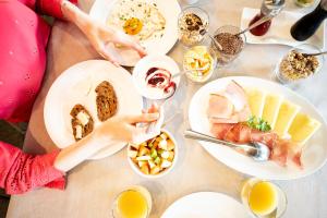 a table full of food with plates of food at Panorama Hotel Flora in Villandro