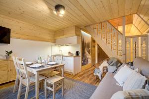 a living room with a table and a kitchen at Domki w Lesie Tylicz in Tylicz