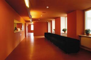 a hallway with a couch in a room with orange walls at Davos Youth Hostel in Davos