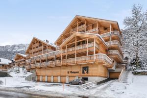 un grand bâtiment en bois dans la neige dans l'établissement Le Montagnier by Mrs Miggins, à Champéry