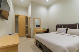 Un pat sau paturi într-o cameră la Vandolia Guest House Mitra RedDoorz