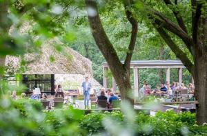a group of people sitting at tables in a garden at Restaurant & Hotel Hoog Holten in Holten