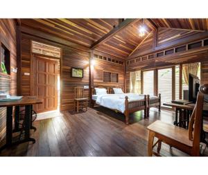 a bedroom with a bed in a room with wooden walls at Mac Garden Resort in Ban Phe