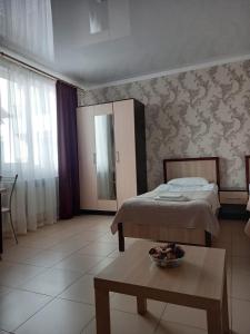 ein Schlafzimmer mit einem Bett und einem Tisch mit einer Schüssel darauf in der Unterkunft Guest house on Kamyshovaya 12 a in Adler