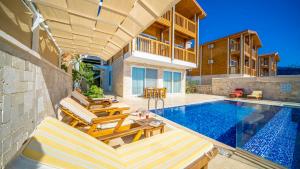 a swimming pool with chairs and a house at Eco Villa Begonvil in Kalkan