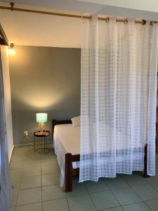 1 dormitorio con 1 cama con cortina blanca en Spacieux Appartement T1 bis Mamoudzou hyper centre, en Mamoudzou