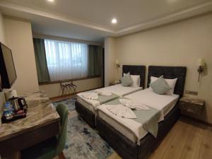 A bed or beds in a room at Florya Novi Hotel