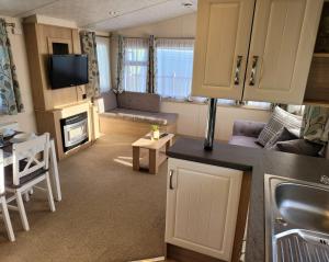 ein kleines Zimmer mit einer Küche und einem Wohnzimmer in der Unterkunft Lovely Static Caravan at Billing Aquadrome in Great Billing