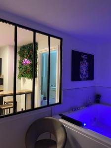 une salle de bains pourpre avec une baignoire et une chaise dans l'établissement L’appart[é] BLACK superbe appartement pop !, à Besançon