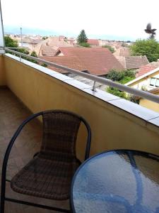 una silla y una mesa en un balcón con vistas en HMM Apartament, en Sibiu