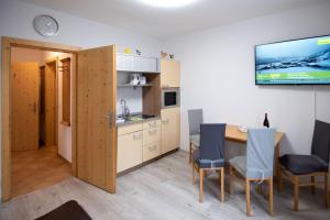 a kitchen and dining room with a table and chairs at Apartmenthaus HAUS Gipfelglück Apartment KUAFSTOA in Haus im Ennstal +6 photos
