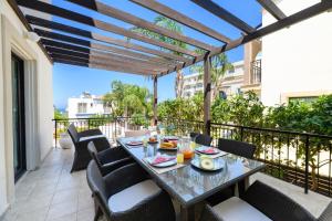 a patio with a table and chairs on a balcony at Protaras Centro Villa in Protaras