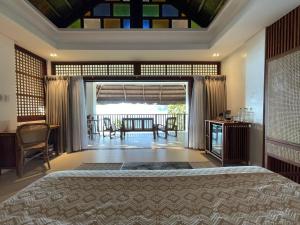 een slaapkamer met een groot bed en een balkon bij Mua Tala Hotel El Nido in El Nido