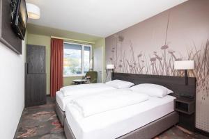 een slaapkamer met 2 bedden en een muur met bloemen bij Hwest Hotel in Hall in Tirol