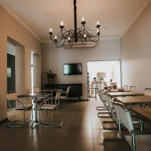 uma sala de jantar com mesas e cadeiras e um lustre em Hotel Hey U em Santa Fé