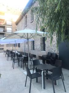 une rangée de tables et de chaises avec parasols dans l'établissement Albergue de Pas, à El Pont de Suert