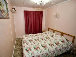 1 dormitorio con cama y cortina roja en Annilahti en Lumivaara