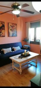 Sala de estar con sofá azul y mesa de centro en Apartamento La Alcancía, en Toledo