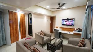 a living room with couches and a flat screen tv at HOTEL J K REGENCY in Mumbai