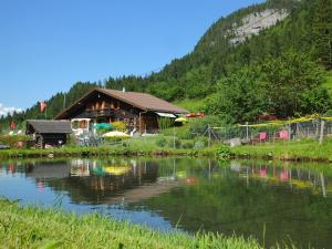 a log cabin next to a lake with a house at Backpacker Le Petit Baroudeur in Champéry