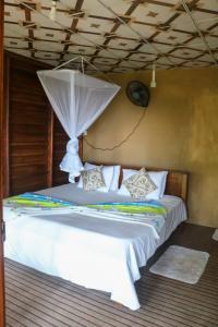 a white bed with an umbrella on top of it at Nice View guest house & restaurant in Ella