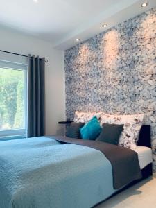 ハイドゥソボスローにあるCornFlower Apartmentの青いベッドと石の壁が備わるベッドルーム1室が備わります。