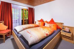 a bedroom with a bed with orange and white pillows at Hartlerlehen Rasp in Berchtesgaden