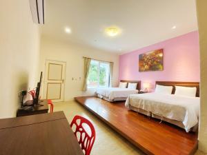 1 dormitorio con 2 camas, mesa y sillas en 獨棟山水心旅棧, en Kenting
