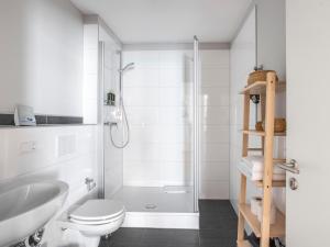 a bathroom with a shower and a toilet and a sink at limehome Aachen Vereinsstraße in Aachen