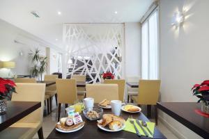 una sala da pranzo con tavolo e cibo di Hotel Gabriel Issy Paris a Issy-les-Moulineaux