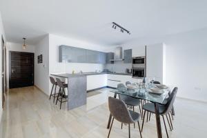 a kitchen and dining room with a table and chairs at Chic 2BR Apartment, Ideal Location in Taʼ Xbiex