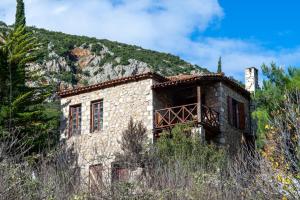 uma velha casa de pedra no lado de uma montanha em MARIOLATA STONE HOUSE em Lílaia
