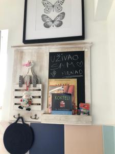 a shelf with books and a picture on a wall at Apartment Jovana Krunska in Belgrade