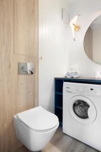 a bathroom with a toilet and a washing machine at Elite Apartments Brzeźno Premium in Gdańsk +15 photos