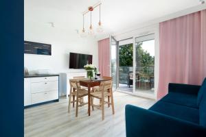 a living room with a table and a blue couch at Elite Apartments Brzeźno Premium in Gdańsk