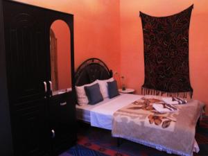 a bedroom with a bed with a black dresser and a bed sidx sidx sidx at Riad De Rêve in Zagora