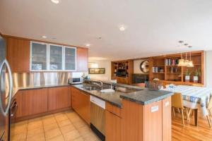 a kitchen with wooden cabinets and a table in it at Northwoods Easy Ski In Ski Out Access in Vail