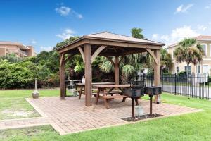 a wooden pavilion with a picnic table and a grill at Ciboney in Destin