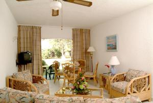 a living room with a couch and chairs and a table at Plum Tree Club in Bridgetown