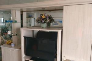 uma televisão numa sala de estar com um vaso de flores em Decatur House em Ocean City