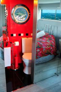 um quarto vermelho com um WC e uma cama em Moinho.com em Rio Maior