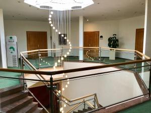 a lobby with stairs and a chandelier with lights at GolfResort Semlin in Semlin