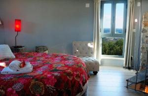 a bedroom with a bed and a chair and a window at Moinho.com in Rio Maior