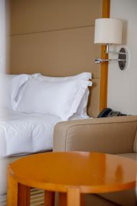 a room with a bed and a table and a couch at Crowne Plaza Sohar, an IHG Hotel in Sohar