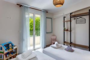 a bedroom with two beds and a large window at Villa 4 DESTINA in Élos +60 photos