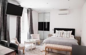 a white bedroom with a bed and a flat screen tv at Apartamento City SOLO ADULTOS in Madrid
