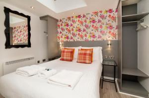 ein Schlafzimmer mit einem weißen Bett und Handtüchern darauf in der Unterkunft City Apartments - Reubens Court in York