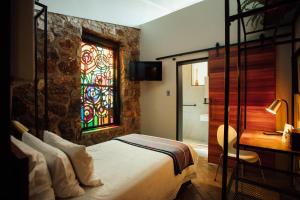 ein Schlafzimmer mit einem Bett und einem Buntglasfenster in der Unterkunft Bastion House in Irene