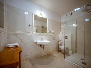 a bathroom with a sink and a shower and a toilet at ApartHotel Hubertus in Białystok