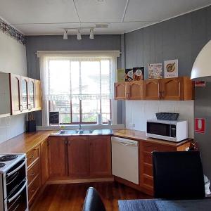 a kitchen with wooden cabinets and a microwave at Sheffield Nine-Nine in Sheffield